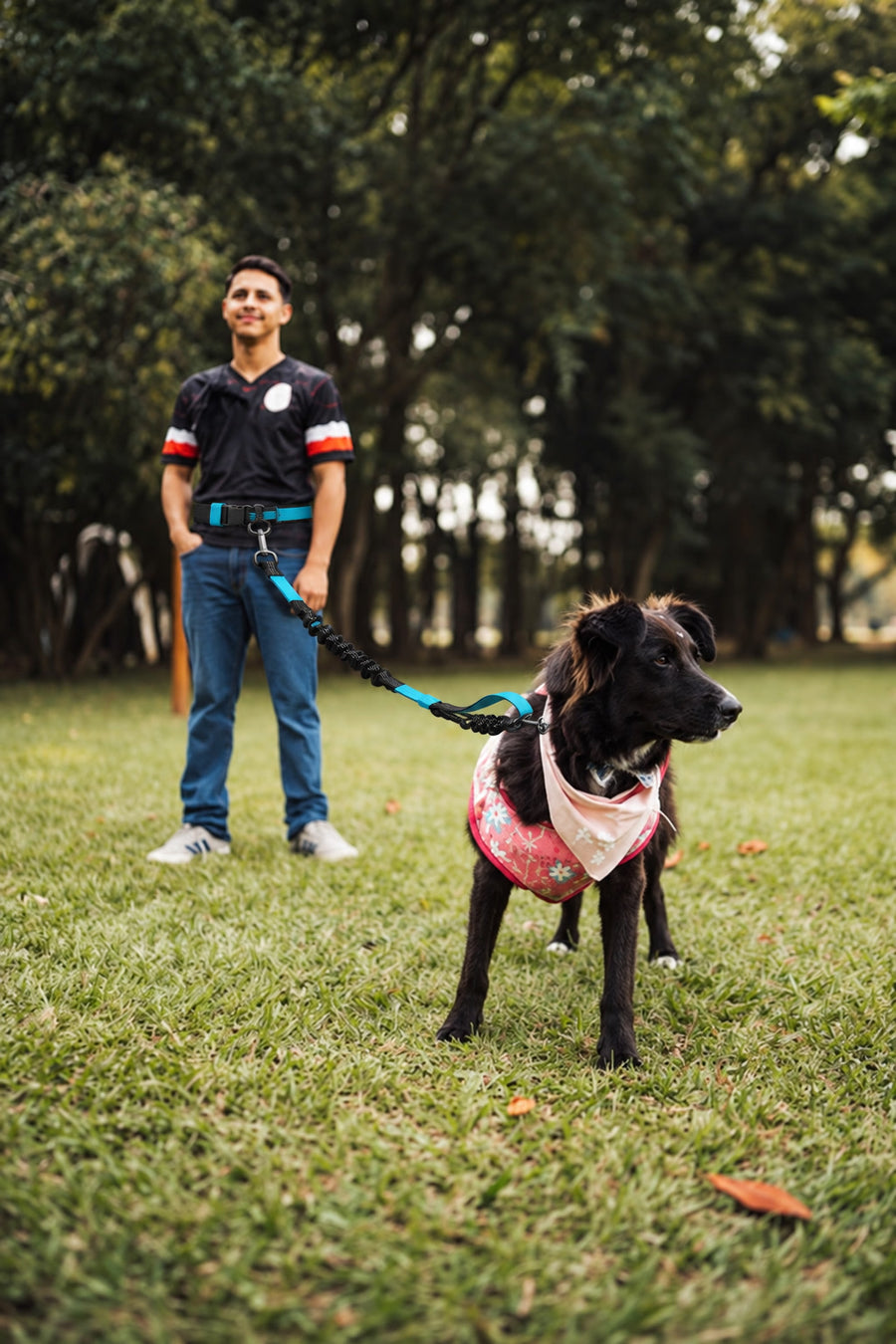 Chico con la correa NOVURA FreeMotion en la cintura y su perro en el parque